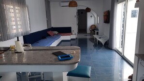 A modern hotel room with a bed, a small dining area, and a view of the outside. - Maison D'hote Saida Djerba Houmt Souk (Sedghiane)