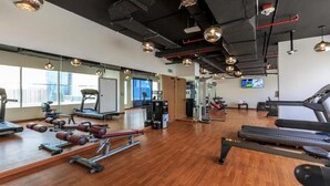 Uma academia com esteiras, aparelhos de musculação e bolas de exercício.