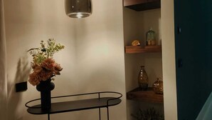 A modern interior with a black metal shelf unit, a hanging pendant light, and a vase with flowers. - B&B SirenaResina - Ligea Standard room (Ercolano)