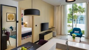 A modern hotel room with a bed, TV, desk, and a view of the outdoors. - One Bedroom Apartment Near Moe By E R (Dubai)