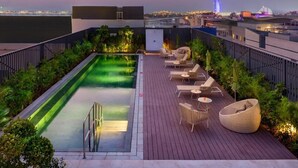 A rooftop pool area with a view of the city skyline, including a prominent building with a sail-like structure. - One Bedroom Apartment Near Moe By E R (Dubai)