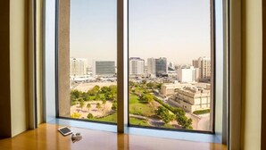 A room with a large window overlooking a cityscape with modern buildings and a park. - Standard Room Near Port Saeed Plaza By E R (Dubai)