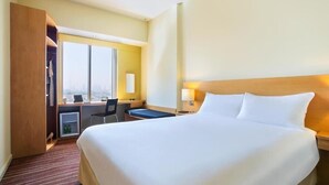 A hotel room with a large bed, a desk, a chair, and a wardrobe. - Standard Room Near Port Saeed Plaza By E R (Dubai)