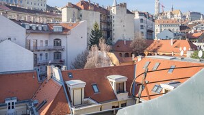 A cityscape with a variety of building styles, including a prominent tower and a cathedral. - Butik Apartments by BQA (Budapest)