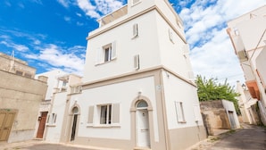 A two-story building with a white facade, a central entrance with a door, and a small balcony on the upper floor. - 3471 Lecasinedico` - Linda Lucia by Barbarhouse (Castrignano del Capo)