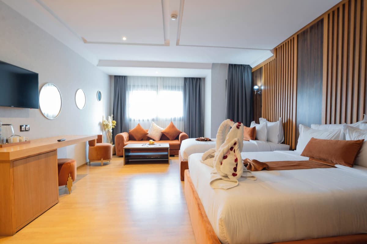 Una habitación de hotel moderna con una cama grande, un sofá, un escritorio y un televisor.