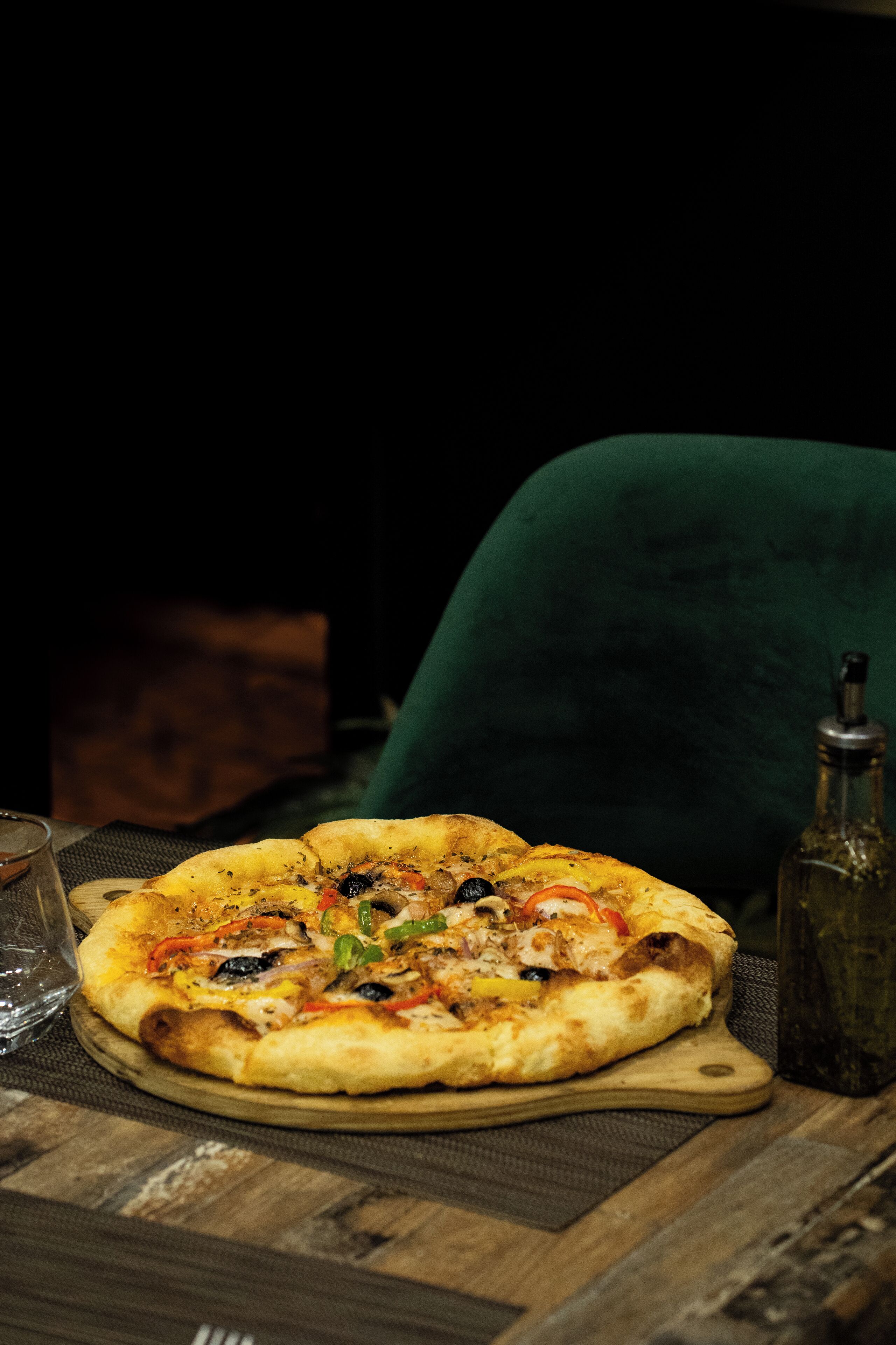 A pizza on a wooden board on a table.