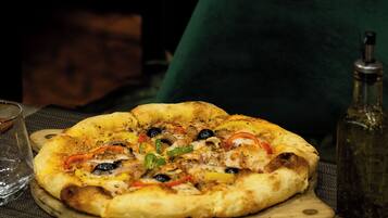 A pizza on a wooden board on a table.