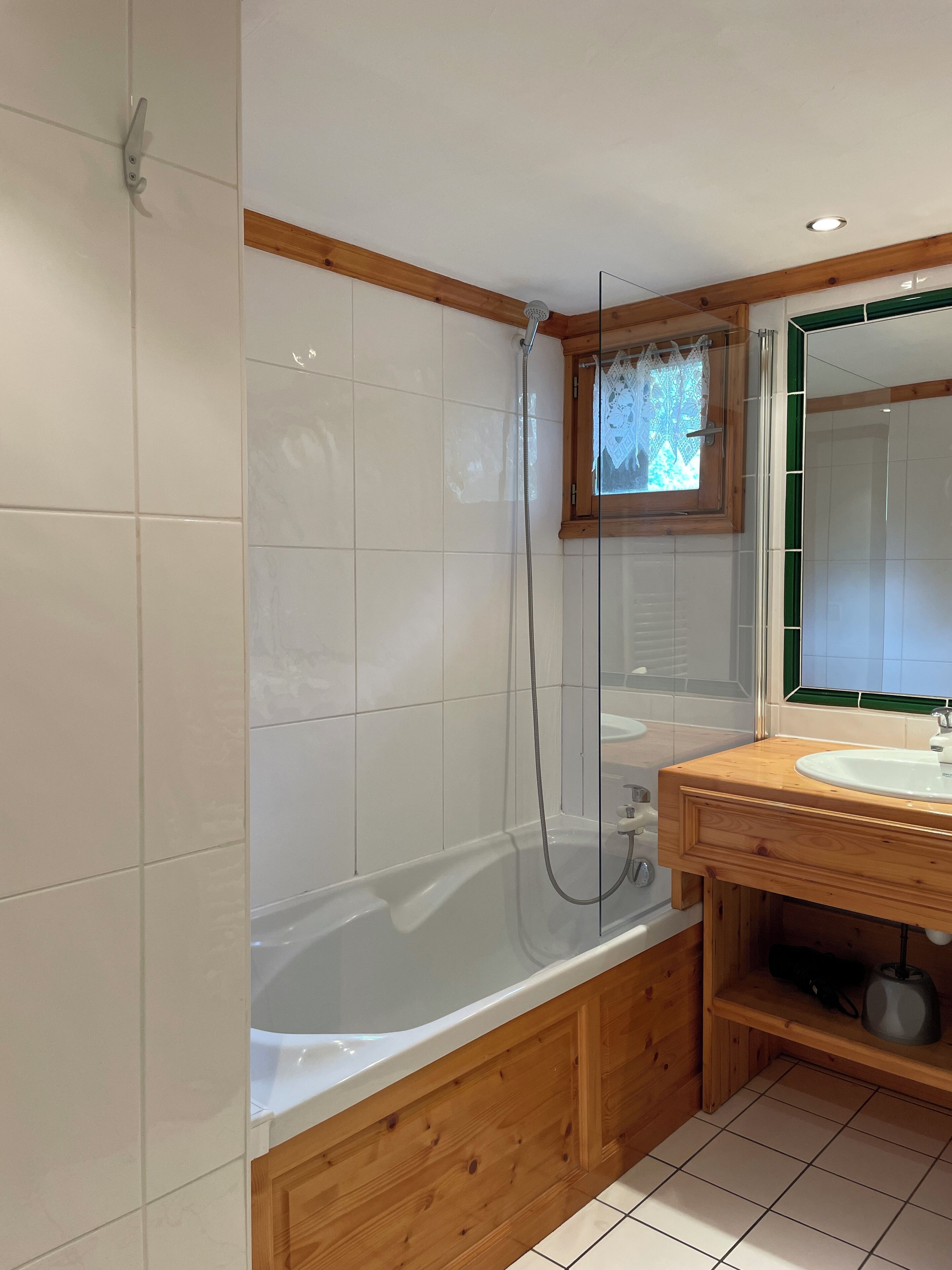 Une salle de bain moderne avec un meuble-lavabo en bois, un grand miroir et une baignoire.