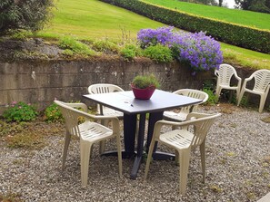 Relax in this serene garden setting with a seating area featuring a table and four chairs.