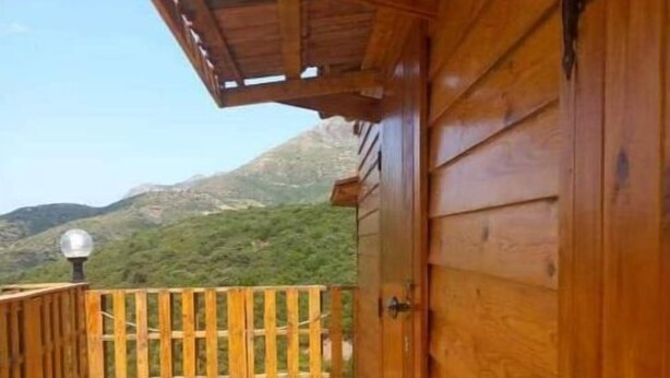 Una terraza de madera con vista a un paisaje montañoso.