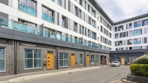 A modern building with multiple floors, large windows, and a sign reading "BISHOPS TERRACE". - 1 Bedroom Luxury Apartment in Redhill (Redhill)