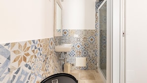 A bathroom with a tiled floor, a sink, and a mirror. - 3396 Leucadense - Grotta 1 by Barbarhouse (Castrignano del Capo)