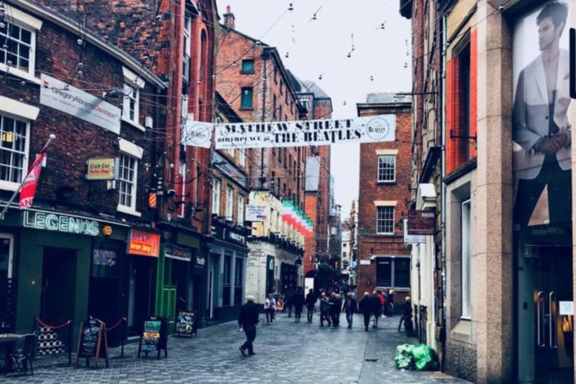 Een straat vol winkels met een banner die The Beatles adverteren.