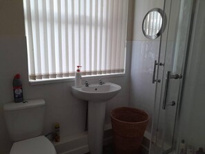 Un baño con inodoro, lavabo y ducha.