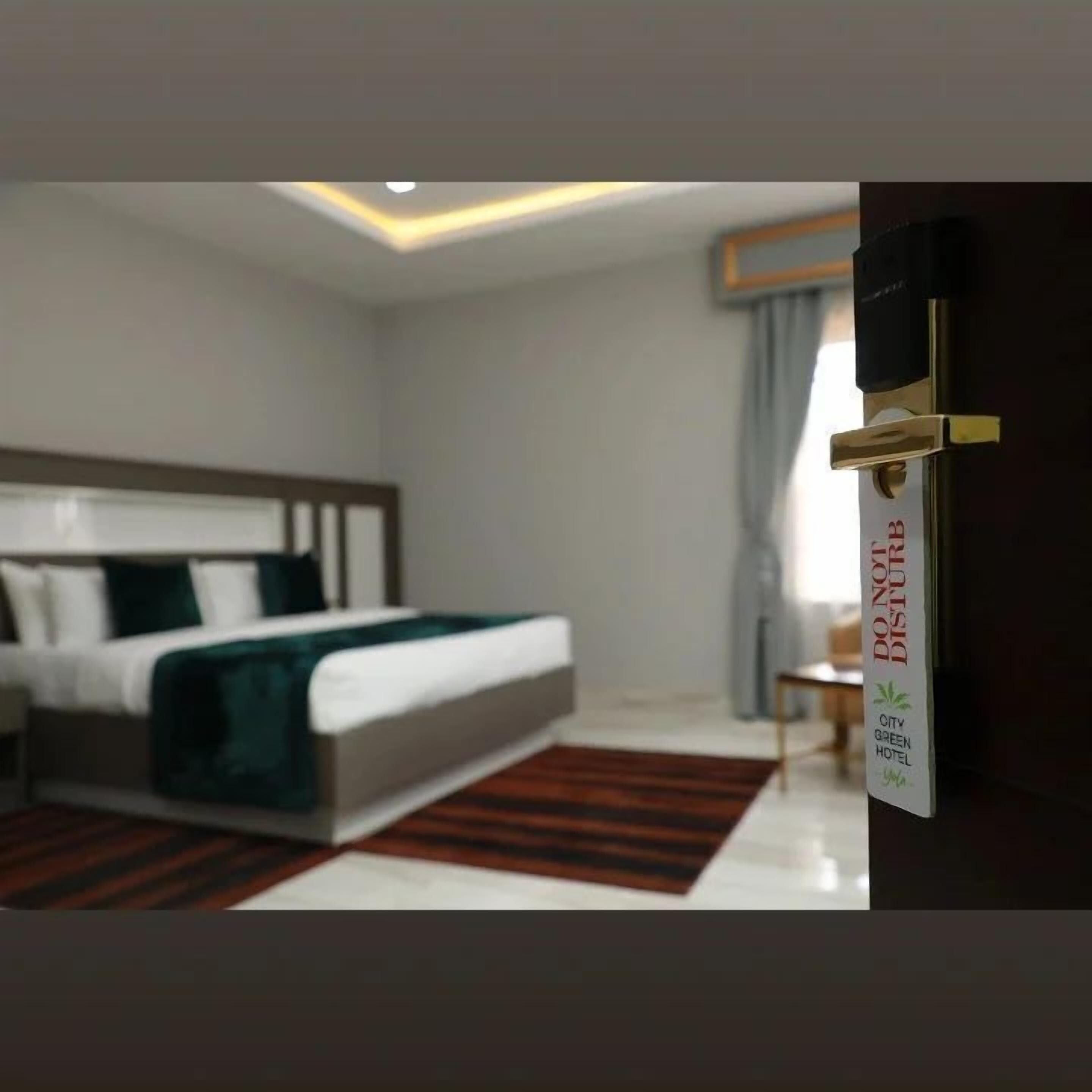 A modern hotel room with a bed, a nightstand, and a sign indicating the hotel is eco-friendly.