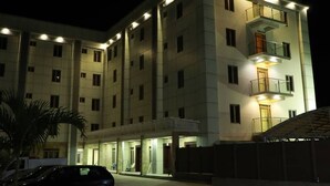 Ein mehrstöckiges Hotel mit modernem Design, mit Balkonen und einem überdachten Eingangsbereich.