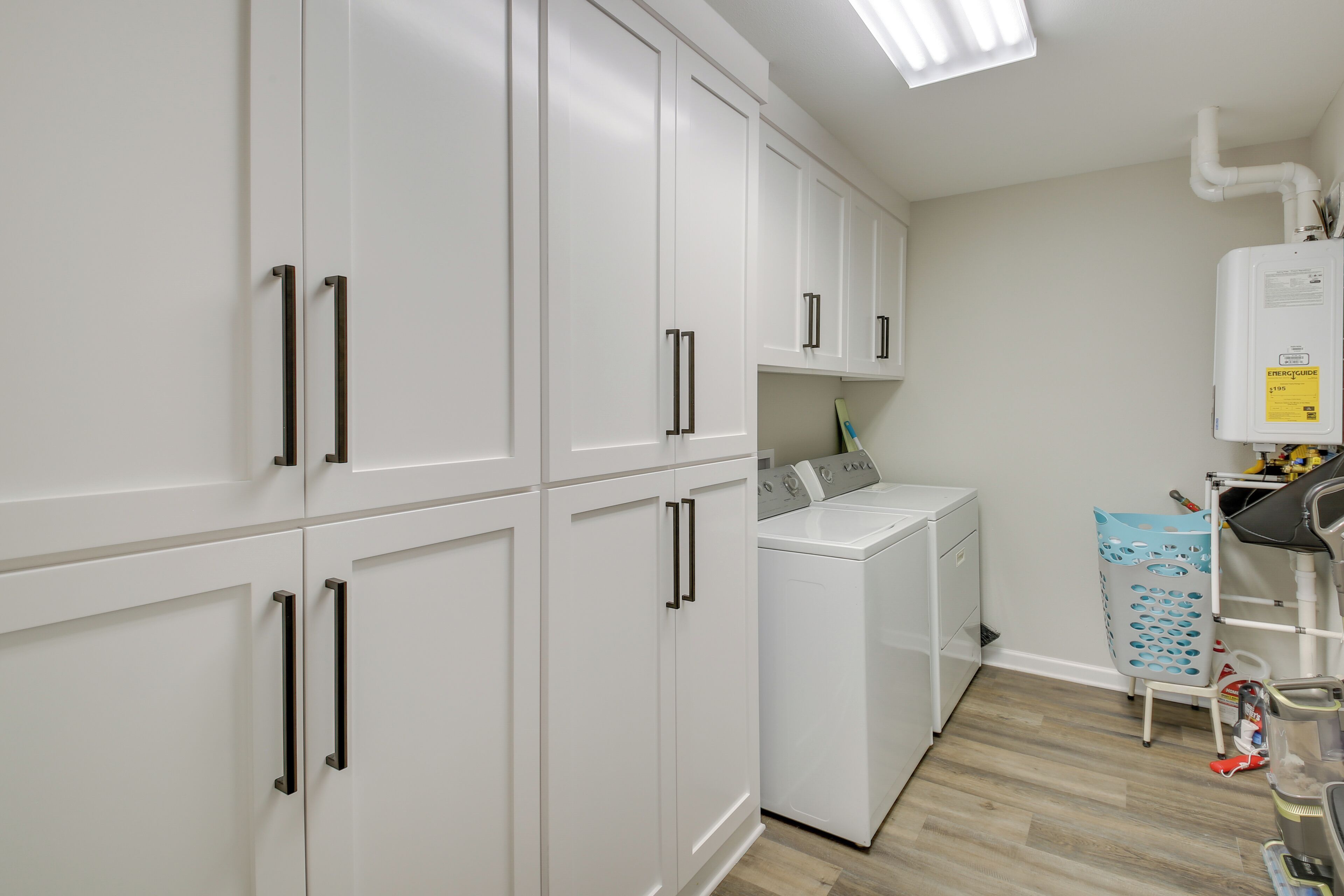 A laundry room with white cabinets, a washing machine, and a drying machine.