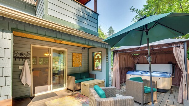 A covered outdoor area with wicker furniture, a hot tub, and a large umbrella. - Historic Mapleton Cottage w/ River Views & Hot Tub (Mapleton)