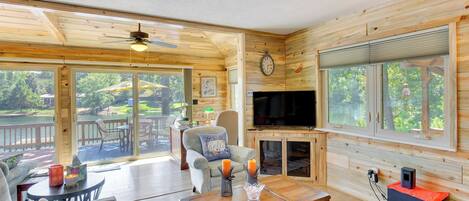 A spacious living room with a wooden interior, a television, and a fireplace.