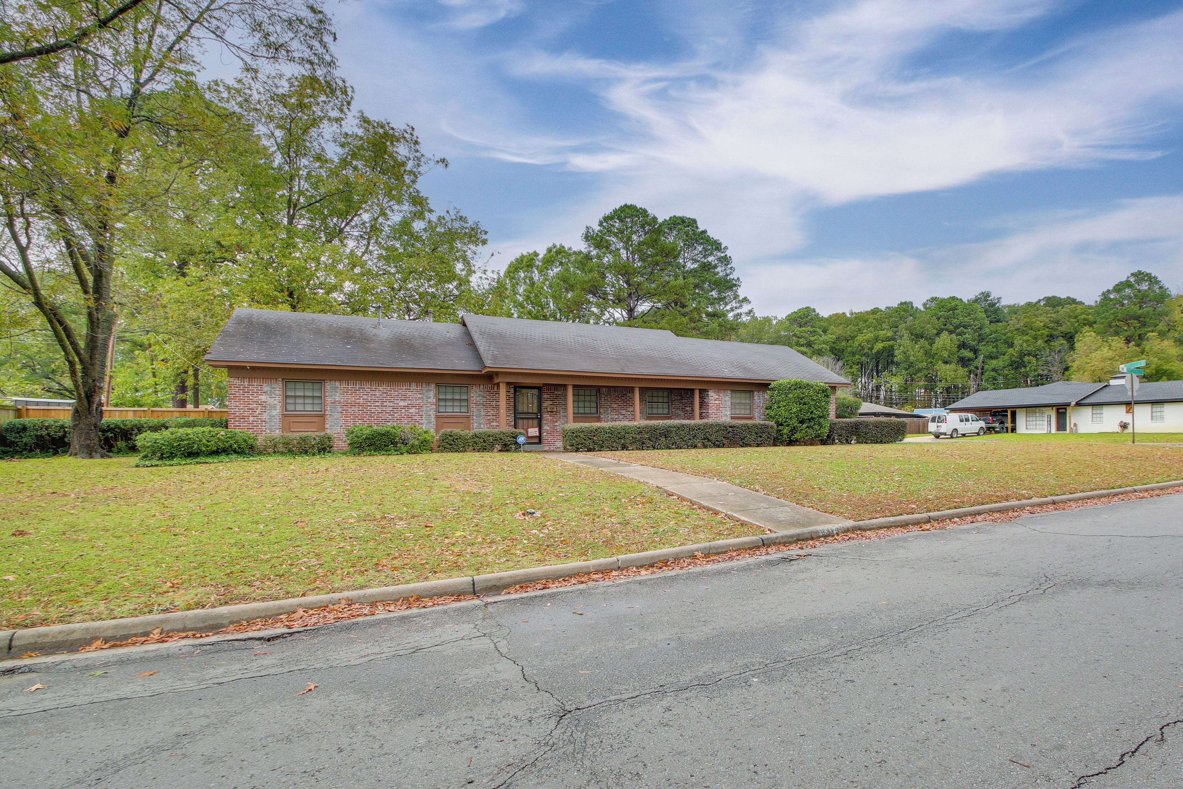 A single-story brick building with a sloped roof, a front entrance, and a small front yard with a sidewalk.