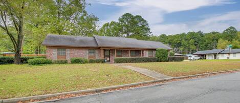 A single-story brick building with a sloped roof, a front entrance, and a small front yard with a sidewalk.