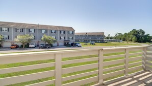 A residential building with multiple floors, a parking area with several cars, and a grassy lawn. - Spacious D'iberville Townhome Near Beach & Casino! (D'Iberville)