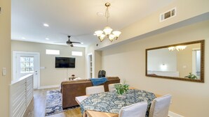 A dining area with a wooden table, chairs, a chandelier, and a large mirror on the wall. - Spacious D'iberville Townhome Near Beach & Casino! (D'Iberville)