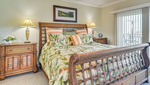 A bedroom with a wooden bed, two nightstands, a ceiling fan, and a window with blinds. - Pool, Beach Access: Waterfront Treasure Island Gem (Treasure Island)