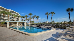 A rectangular swimming pool with a tiled deck, surrounded by lounge chairs and palm trees. - Pool, Beach Access: Waterfront Treasure Island Gem (Treasure Island)