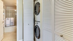 A laundry room with two stacked washers and dryers, a glass shower enclosure, and a door leading to a bathroom. - Pool, Beach Access: Waterfront Treasure Island Gem (Treasure Island)