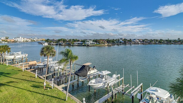 A marina with boats docked, a grassy area, and a clear sky. - Pool, Beach Access: Waterfront Treasure Island Gem (Treasure Island)
