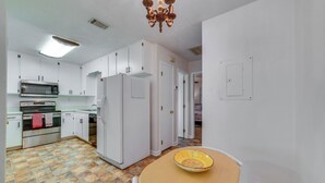 A kitchen with white cabinets, a microwave, an oven, and a refrigerator. - Cozy Tallahassee Home - 2 Mi to Governors Square! (Tallahassee)