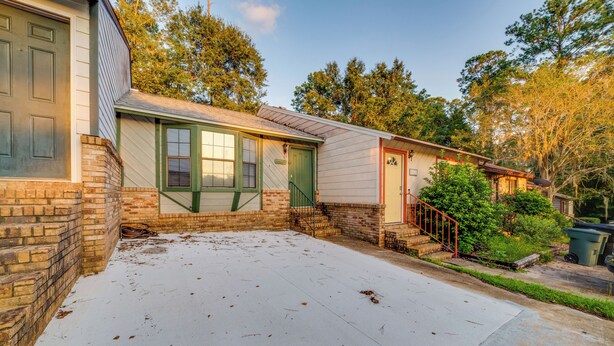 A single-story house with a brick foundation, a covered patio, and a small front yard. - Cozy Tallahassee Home - 2 Mi to Governors Square! (Tallahassee)