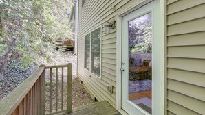 A wooden deck with a door leading to a covered patio area. - Asheville Retreat ~ 6 Mi to Biltmore & Downtown! (Asheville)