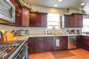 A modern kitchen with dark wood cabinets, stainless steel appliances, and a large island. - Spacious Retreat < 3 Mi to Downtown Flagstaff! (Flagstaff)