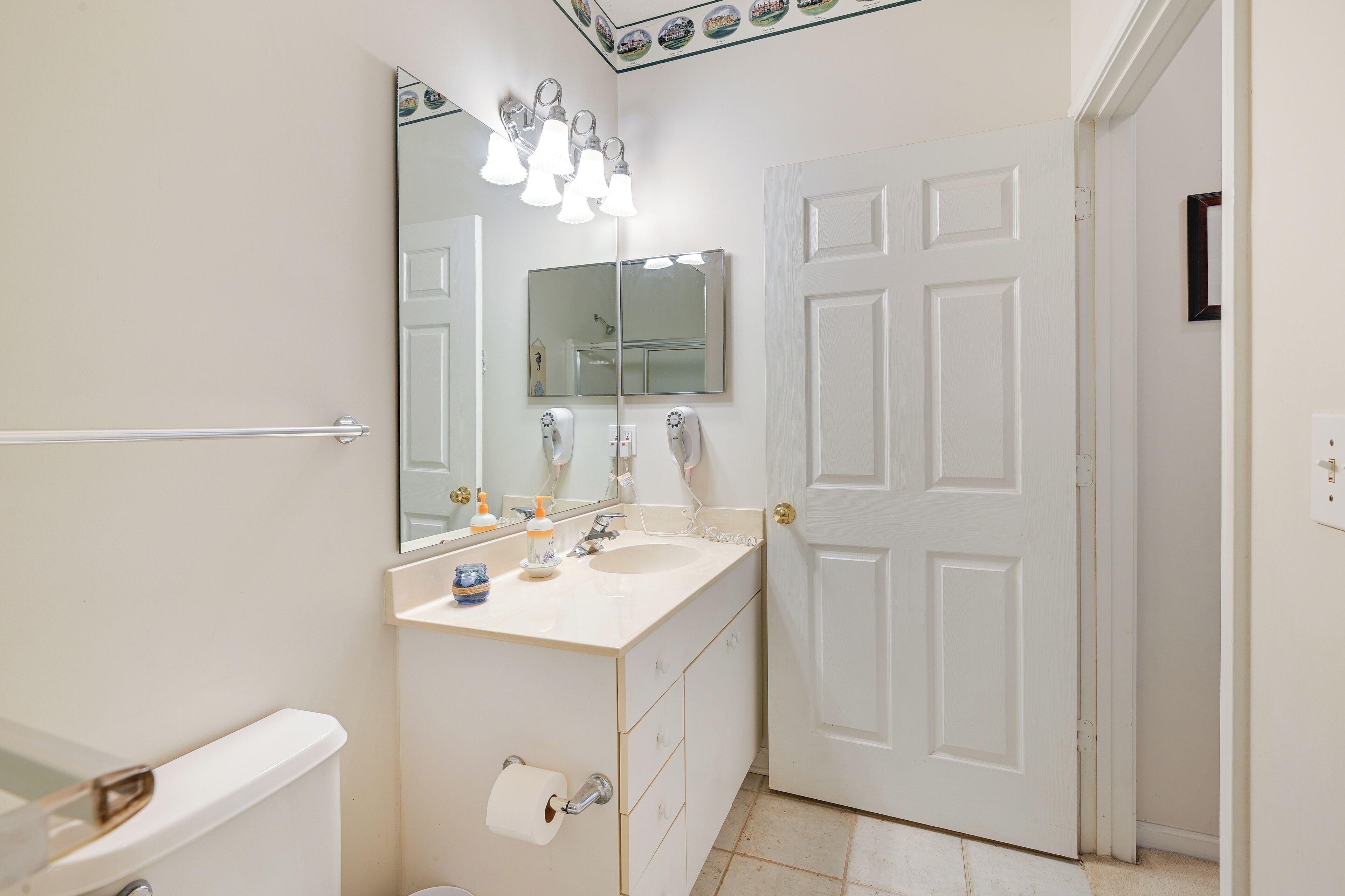 A bathroom with a white toilet, a sink with a mirror above it, and a towel rack.