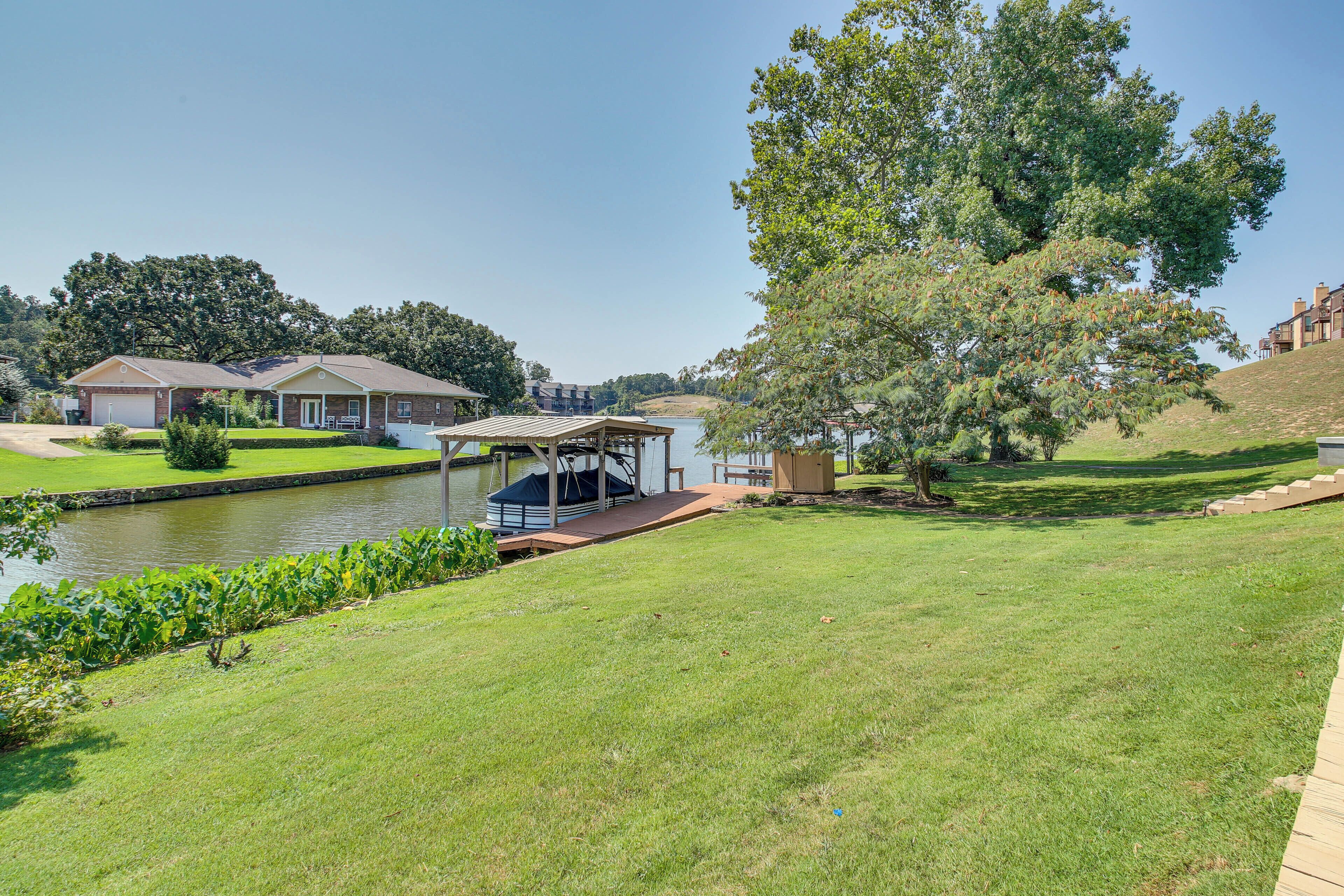 A residential area with a house, a dock, and a large tree.