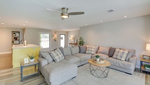 A modern living room with a sectional sofa, a coffee table, and a ceiling fan. - Peaceful Hot Springs Home: Deck w/ Water Views! (Hot Springs)