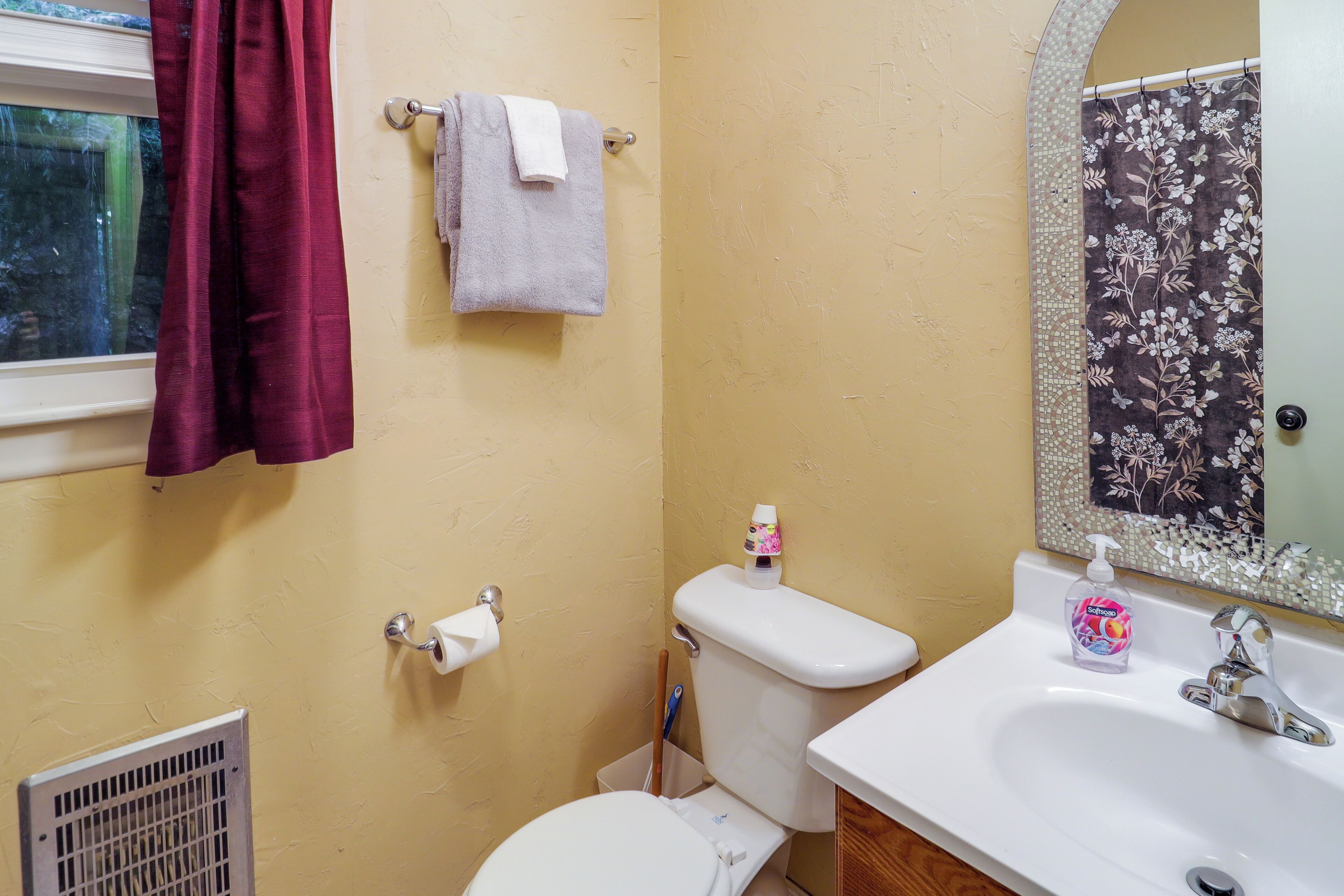 A bathroom with a toilet, sink, and a shower curtain.