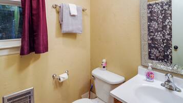 A bathroom with a toilet, sink, and a shower curtain.