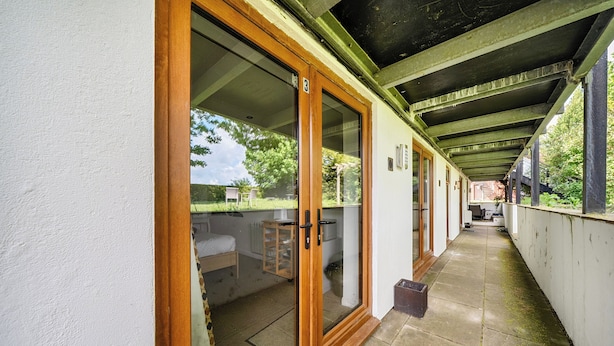 Un corredor cubierto con puertas de vidrio correderas que dan a un patio.