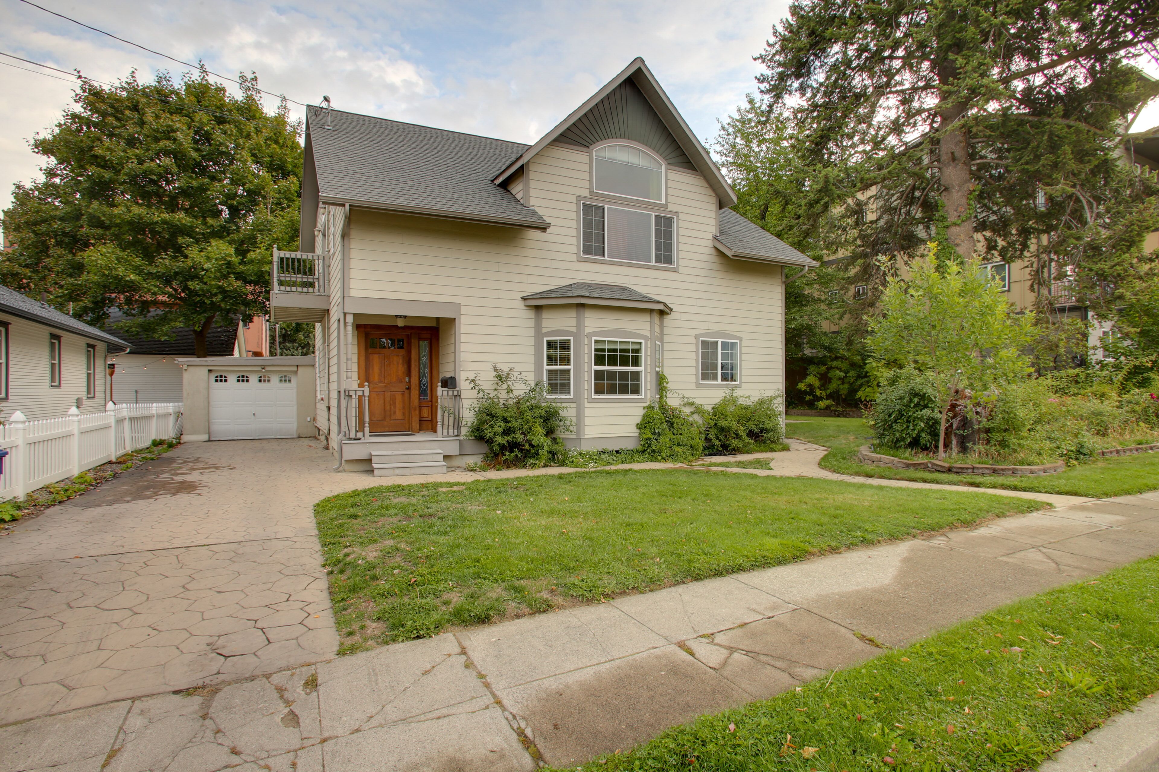 A two-story house with a front porch, a garage, and a well-maintained lawn.