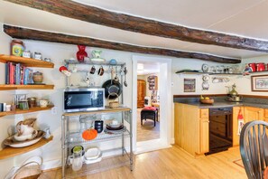 A kitchen with wooden beams, shelves with kitchenware, a microwave, and a dishwasher. - Historic Boonsboro Vacation Rental w/ Grill (Boonsboro)