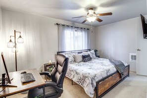 A bedroom with a bed, a desk with a computer, a chair, a ceiling fan, and a window with curtains. - Updated Deck & Fireside Table: Pinetop Cottage (Pinetop)
