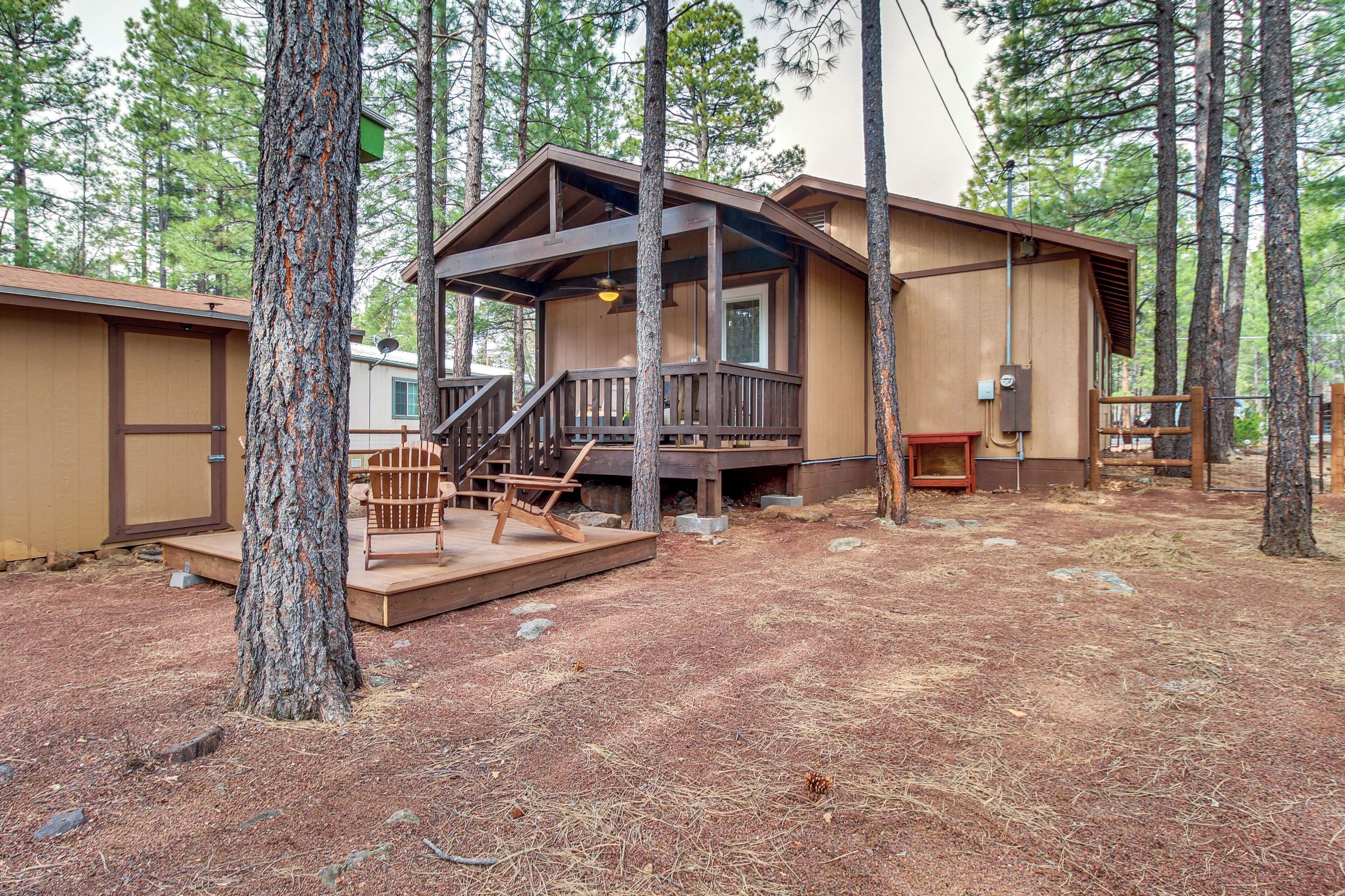 A cabin with a wooden deck, a staircase, and a small porch area.
