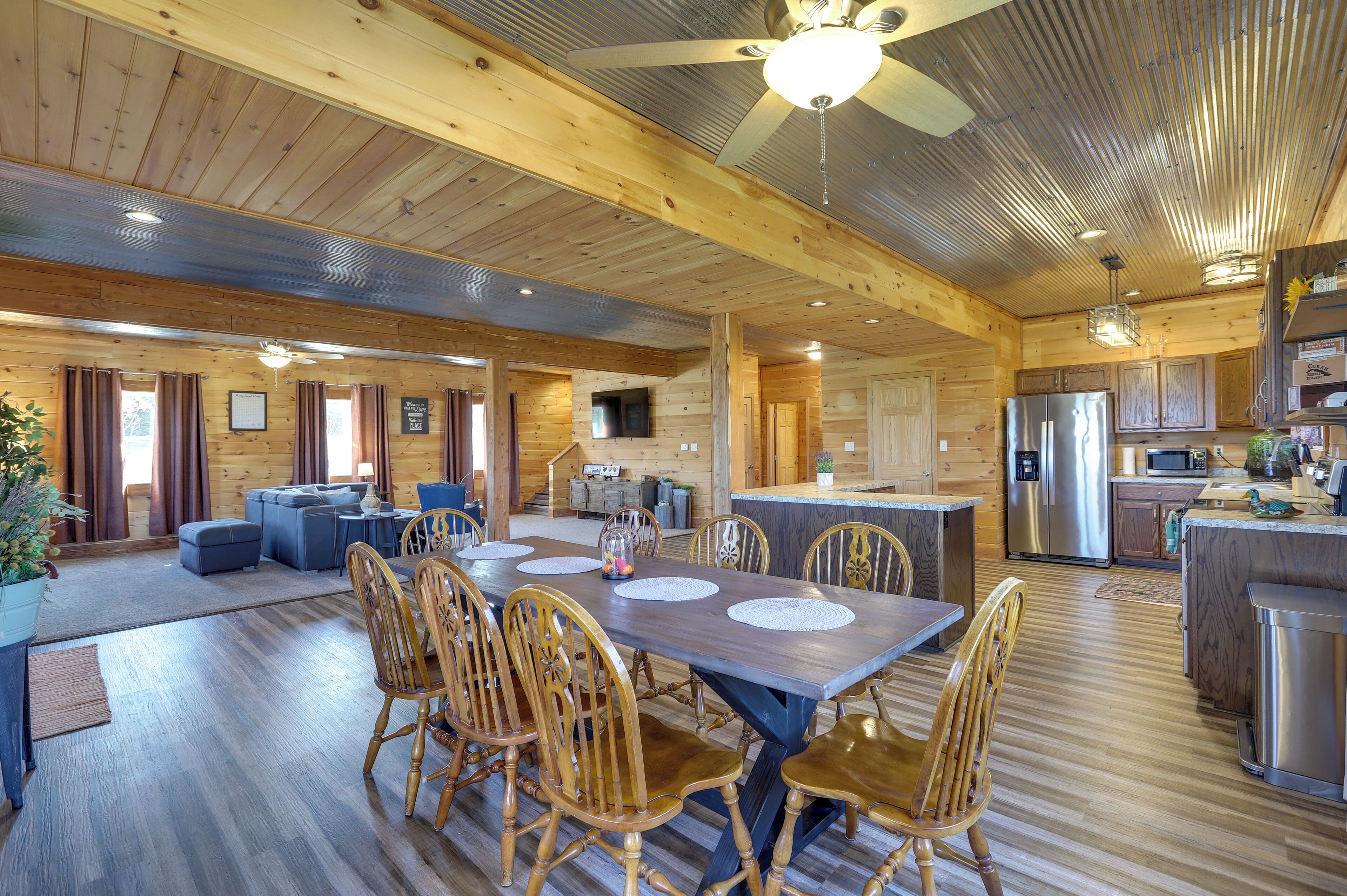 A spacious wooden cabin with a large dining area, kitchen, and living room.