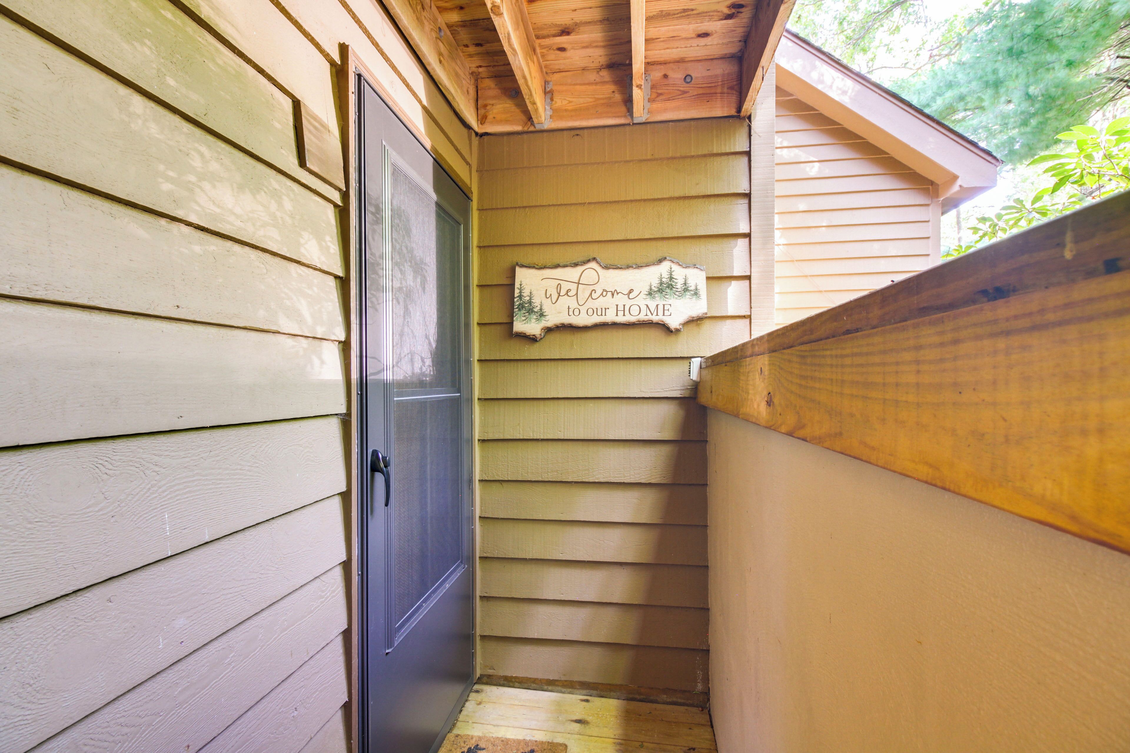 A wooden exterior wall with a 'Welcome to our HOME' sign.