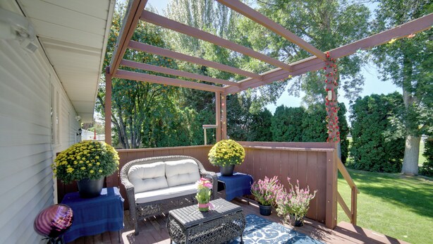 A covered patio with a sofa, a coffee table, and potted plants. - Simple + Charming Idaho Retreat w/ Patio! (Idaho Falls)