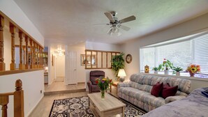 A living room with a sofa, a coffee table, a chair, a ceiling fan, and a window with blinds. - Simple + Charming Idaho Retreat w/ Patio! (Idaho Falls)